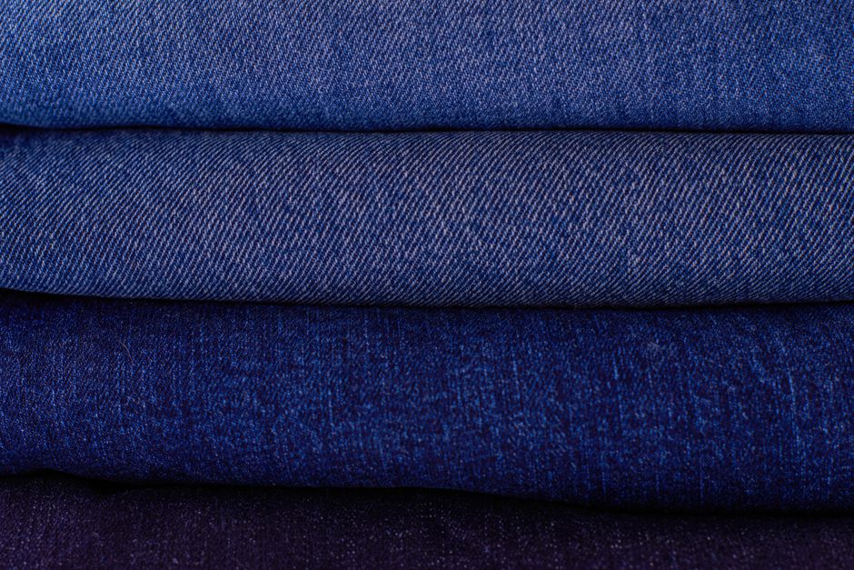 Telas de denim dobladas y apiladas en distintos tonos de azul
